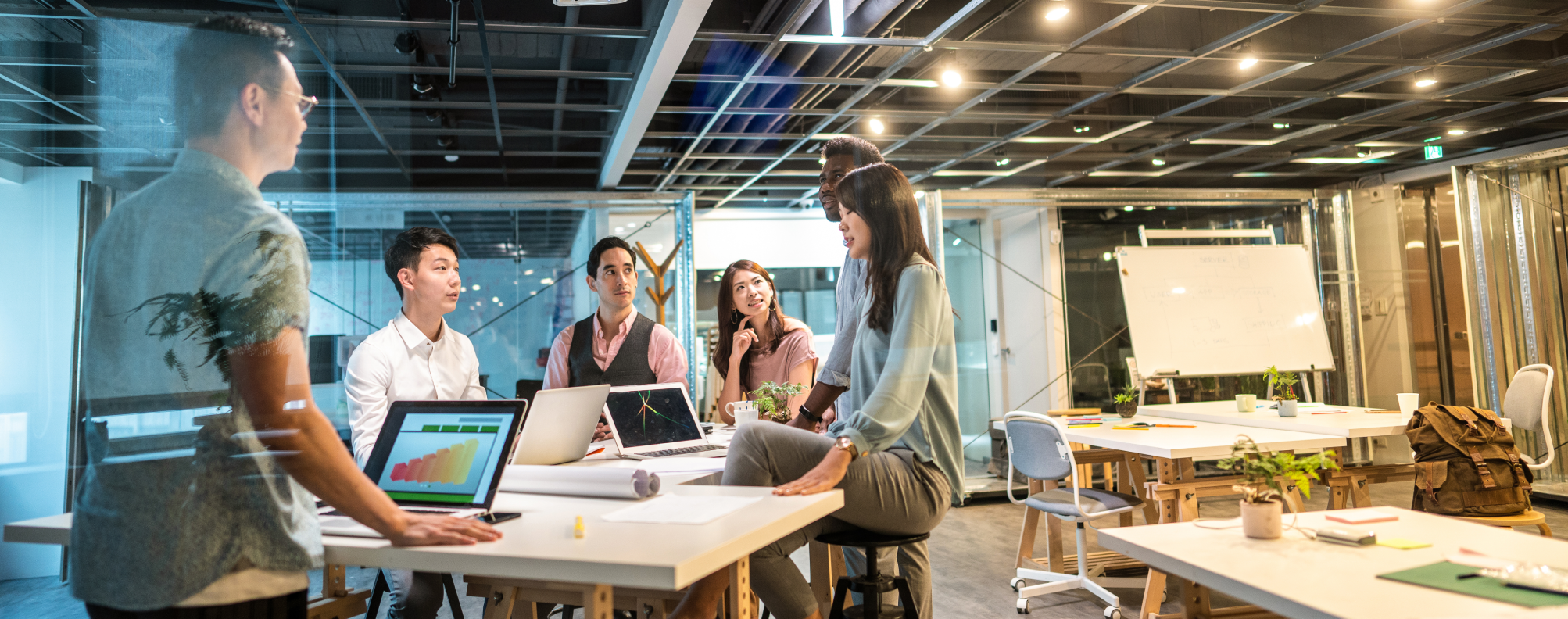 A group of colleagues gathered around a table in an open office.