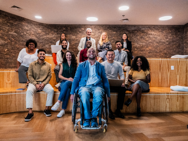 A group of colleagues sitting together on benches and a wheelchair.